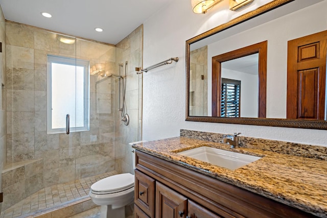 bathroom with toilet, a shower stall, recessed lighting, and vanity