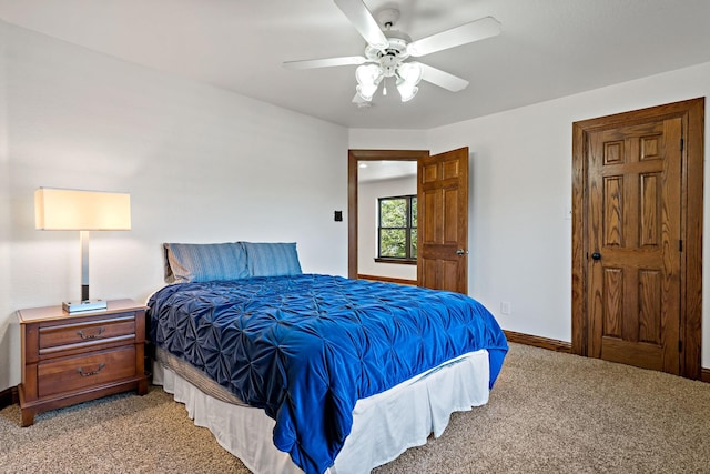 bedroom with light carpet, ceiling fan, and baseboards