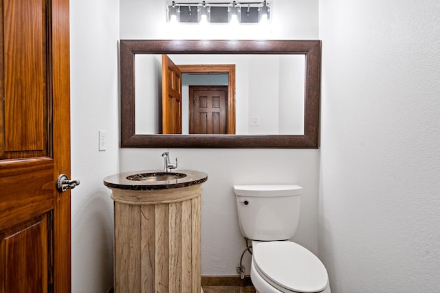 half bathroom featuring vanity and toilet