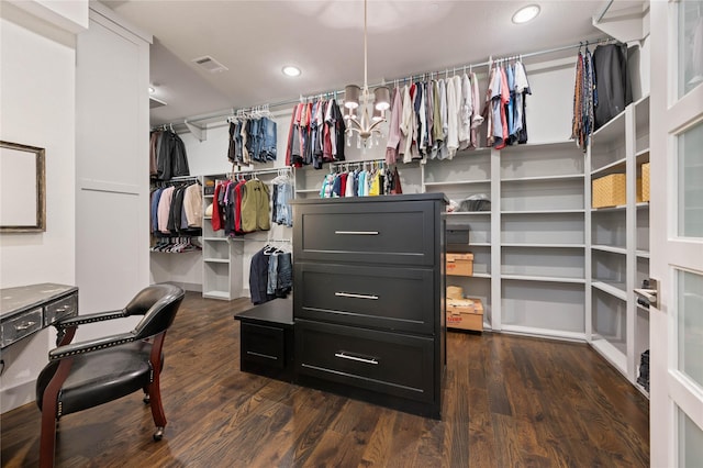 spacious closet with a notable chandelier, visible vents, and dark wood-style flooring