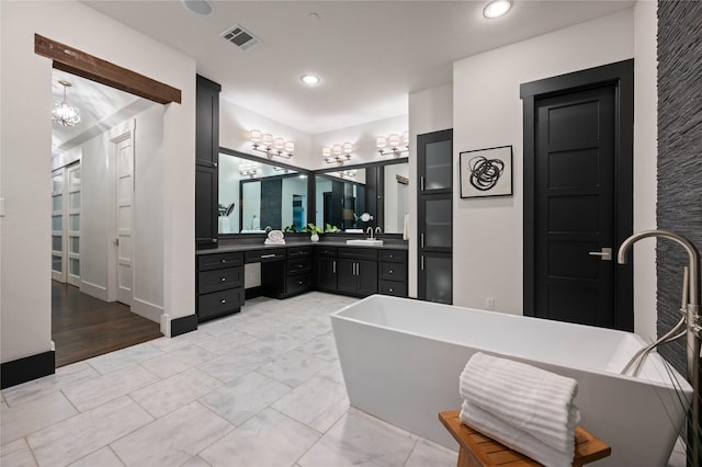 full bath with recessed lighting, visible vents, an inviting chandelier, vanity, and a freestanding tub