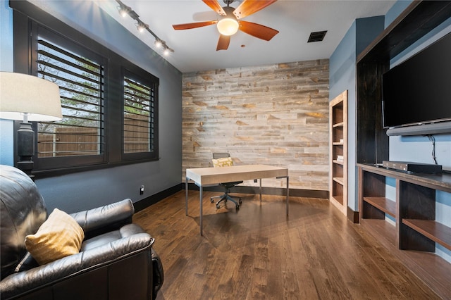 office space with an accent wall, visible vents, wooden walls, and wood finished floors