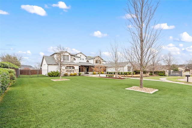 back of property with a residential view, a lawn, and fence