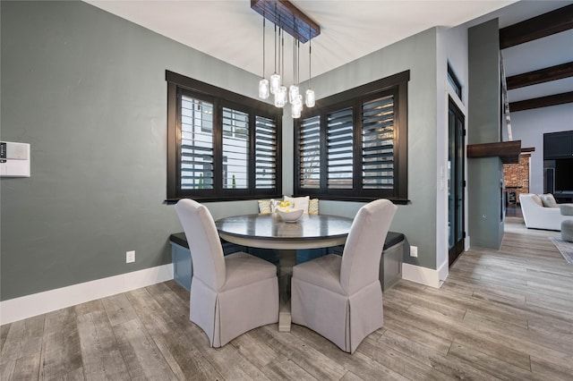 dining space with wood finished floors, baseboards, and an inviting chandelier