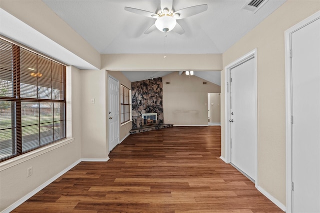 corridor featuring lofted ceiling, baseboards, visible vents, and wood finished floors