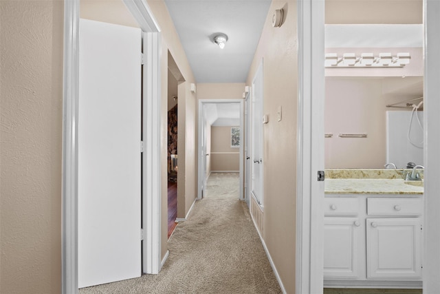 hallway with light carpet and baseboards