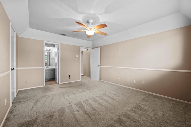 unfurnished bedroom featuring ensuite bathroom, carpet floors, a ceiling fan, visible vents, and baseboards