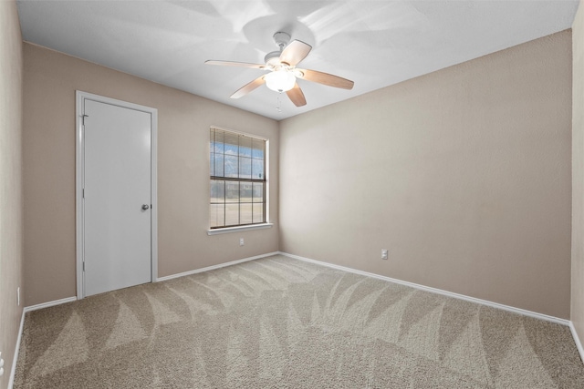 empty room featuring carpet floors, ceiling fan, and baseboards