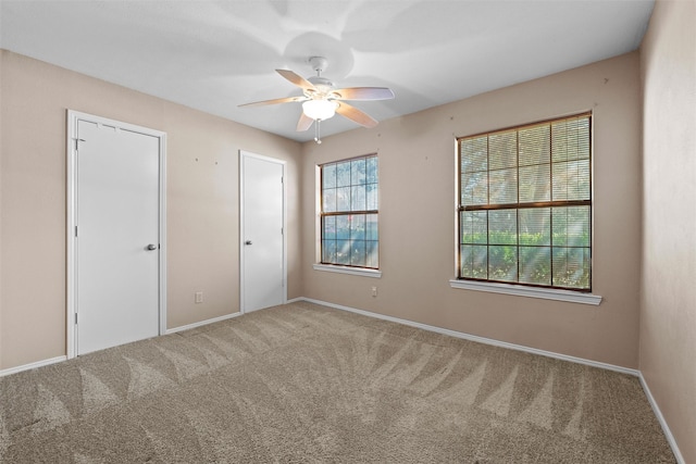 unfurnished room featuring carpet, baseboards, and ceiling fan