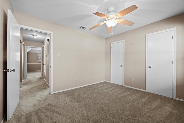 unfurnished bedroom featuring ceiling fan, carpet flooring, visible vents, and baseboards