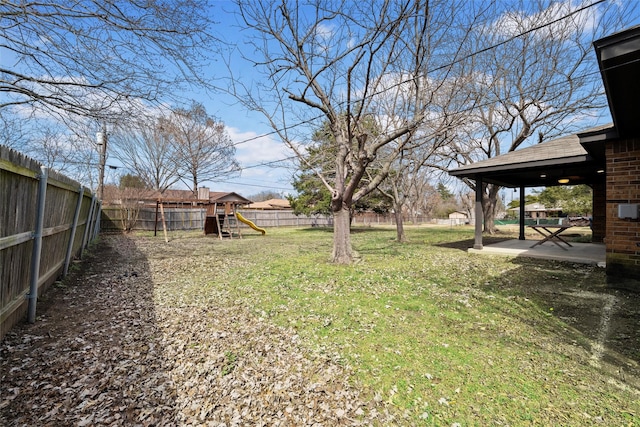 view of yard featuring a patio, a playground, and a fenced backyard