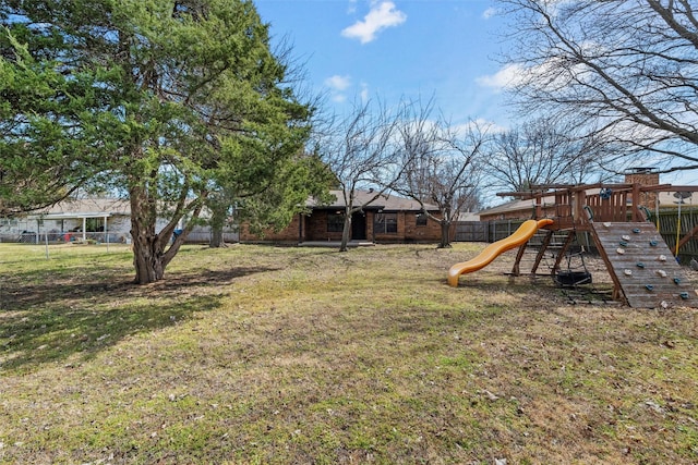 view of yard featuring a playground and fence