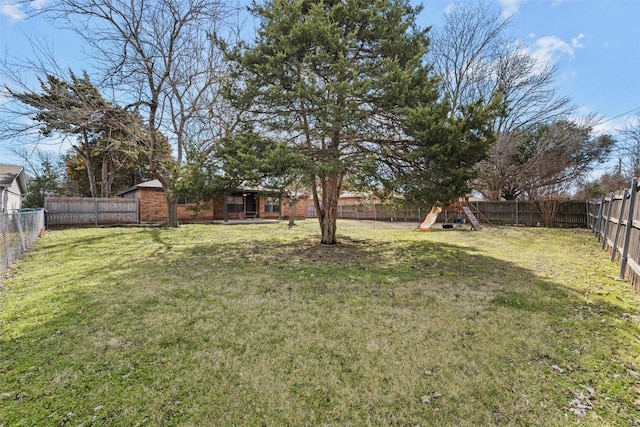 view of yard featuring a fenced backyard and a playground