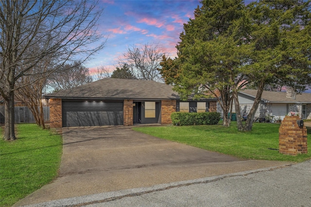 ranch-style house featuring a garage, driveway, brick siding, and a lawn