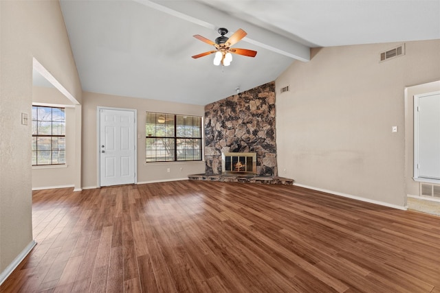 unfurnished living room featuring a healthy amount of sunlight, a fireplace, visible vents, and wood finished floors