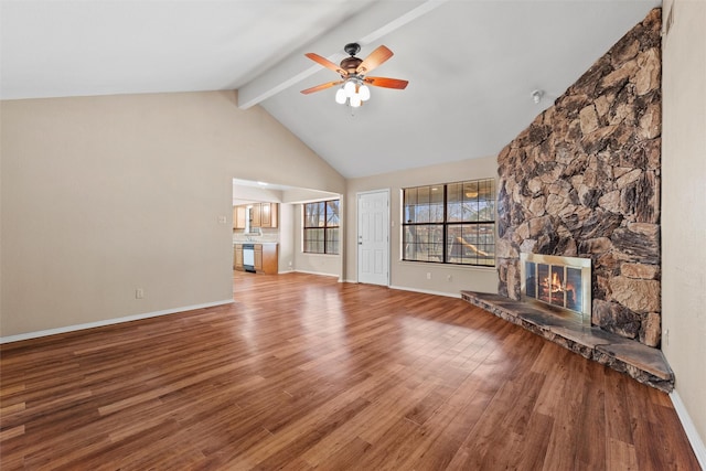 unfurnished living room featuring a fireplace, ceiling fan, wood finished floors, beamed ceiling, and baseboards