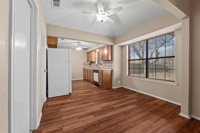 kitchen featuring visible vents, dark wood-type flooring, freestanding refrigerator, and dishwasher