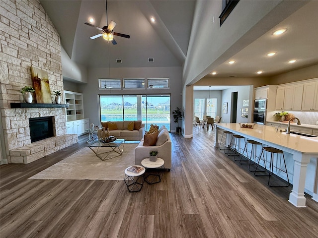 living room with visible vents, baseboards, dark wood finished floors, recessed lighting, and a fireplace