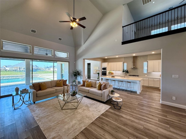 living area with visible vents, baseboards, and wood finished floors