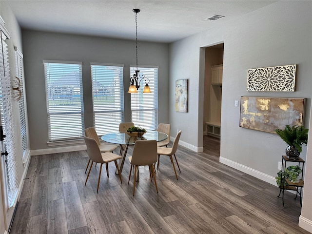 dining space with visible vents, wood finished floors, and baseboards