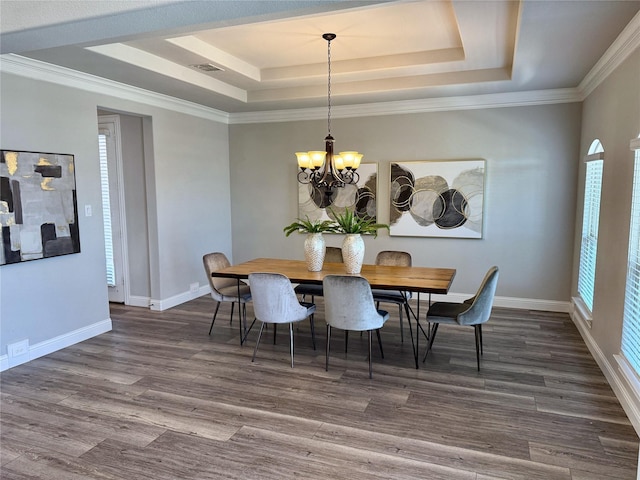 dining space featuring visible vents, a raised ceiling, an inviting chandelier, and dark wood-style flooring