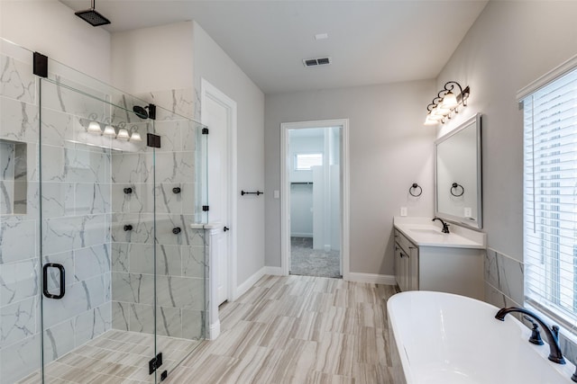 bathroom featuring visible vents, baseboards, a stall shower, a freestanding tub, and vanity