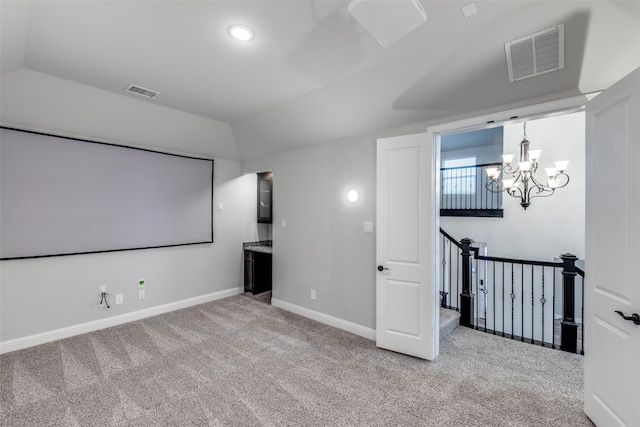 home theater room featuring visible vents, carpet, and vaulted ceiling