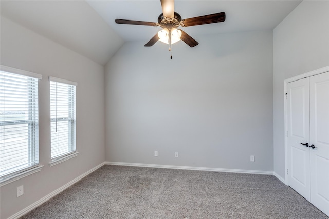 carpeted spare room with baseboards, a ceiling fan, and lofted ceiling