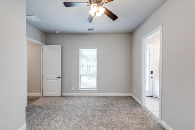 unfurnished room with visible vents, baseboards, a ceiling fan, and carpet flooring