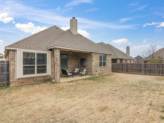 back of property featuring a patio, brick siding, roof with shingles, and a fenced backyard