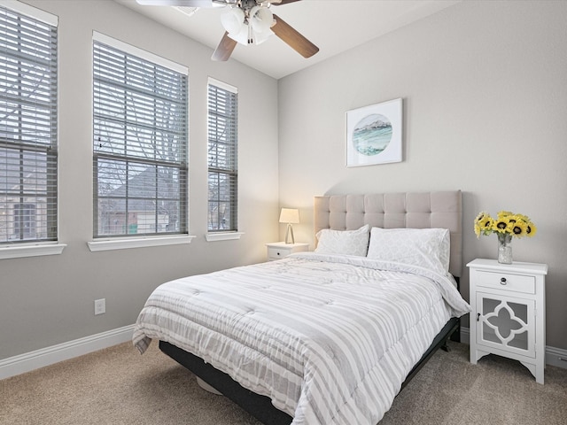 carpeted bedroom featuring baseboards and a ceiling fan