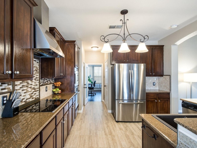 kitchen featuring visible vents, dark brown cabinets, stainless steel appliances, and wall chimney exhaust hood