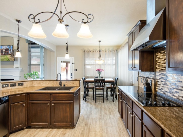 kitchen with a sink, dark brown cabinetry, wall chimney range hood, black electric cooktop, and dishwasher