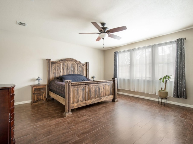 bedroom featuring visible vents, a ceiling fan, dark wood-type flooring, and baseboards