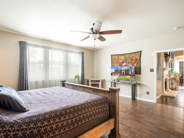 bedroom with a ceiling fan, baseboards, and wood finished floors