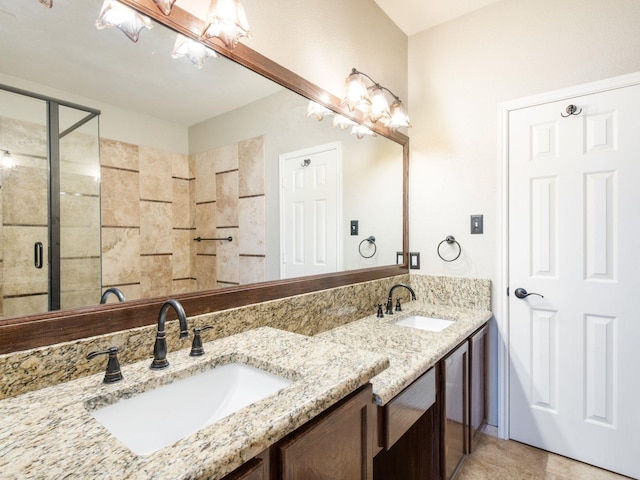 bathroom featuring a shower stall, double vanity, and a sink