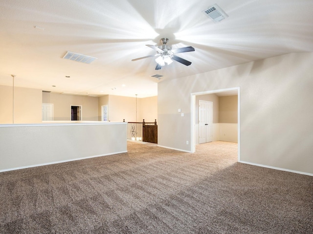 empty room featuring visible vents, carpet floors, and baseboards