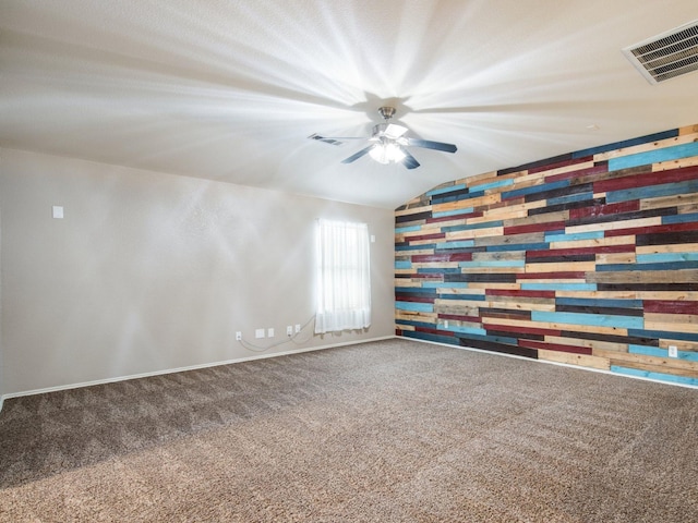 carpeted spare room with visible vents, baseboards, and vaulted ceiling