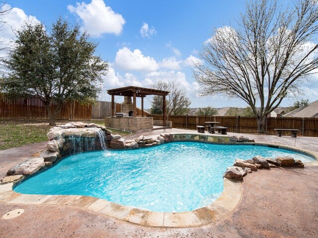 view of swimming pool featuring a patio area, a fenced in pool, a fireplace, and a fenced backyard