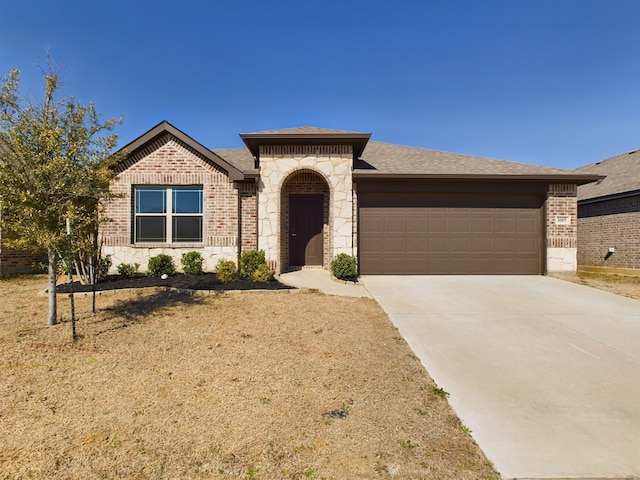 view of front of home with a garage, concrete driveway, brick siding, and stone siding