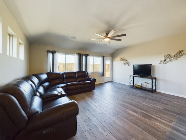 living room with ceiling fan, dark wood-type flooring, visible vents, baseboards, and vaulted ceiling