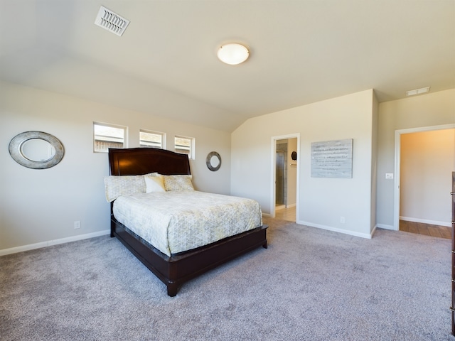 bedroom with vaulted ceiling, carpet flooring, visible vents, and baseboards