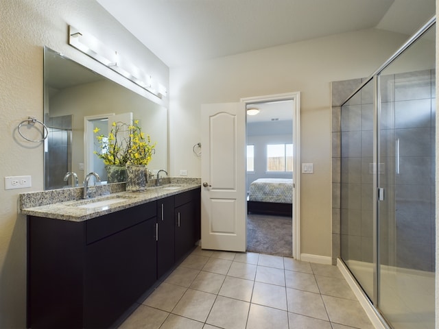 full bath featuring double vanity, a shower stall, a sink, and tile patterned floors