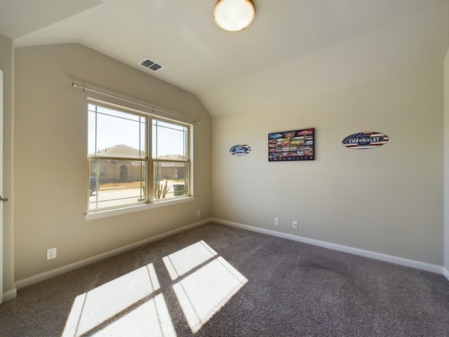 empty room with lofted ceiling, baseboards, and visible vents