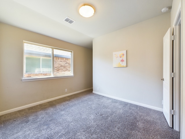 carpeted spare room with visible vents and baseboards