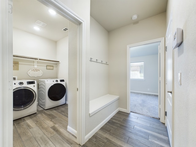 laundry area with laundry area, light wood-style flooring, washer and clothes dryer, and visible vents