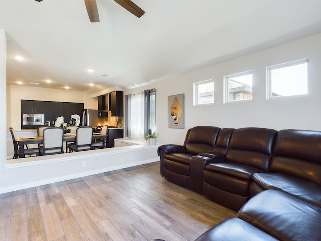 living area featuring light wood-style flooring, ceiling fan, and recessed lighting