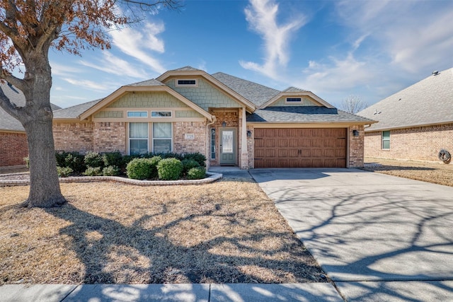 craftsman-style home with a garage, roof with shingles, driveway, and brick siding