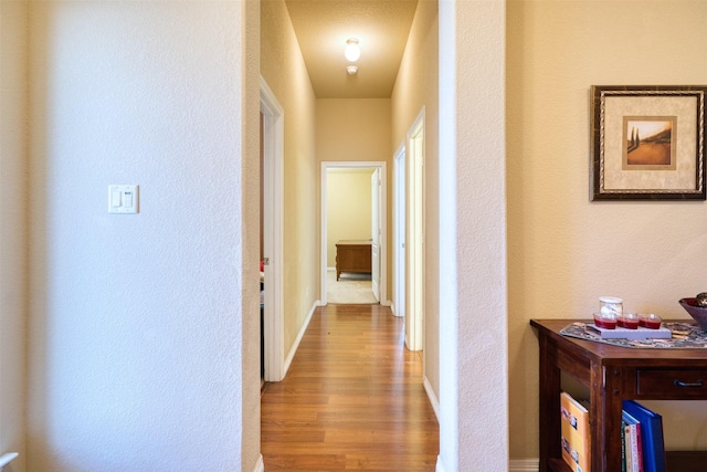 hallway with wood finished floors and baseboards