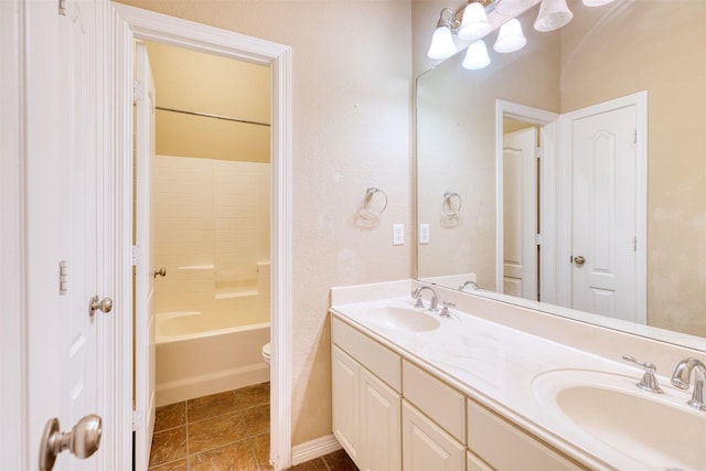 bathroom with double vanity, toilet, a sink, and tile patterned floors